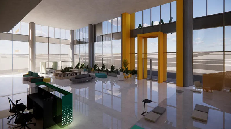 Double-height lobby with yellow frame columns and polished white floor reflecting daylight from floor-to-ceiling windows