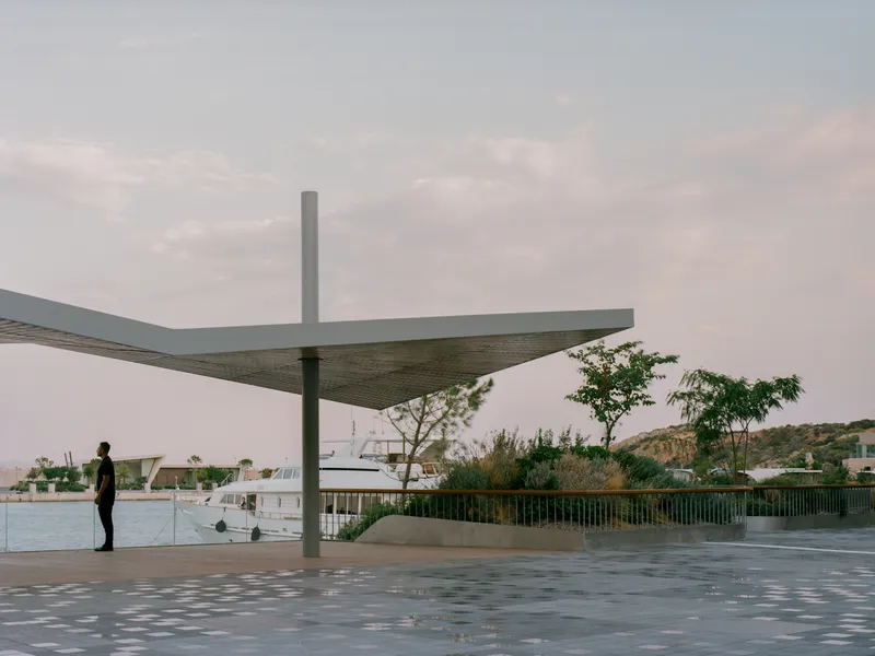 Cantilevered canopy supported by a single column overlooking the waterfront under an overcast sky