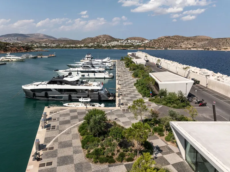 Elevated view of the patterned stone promenade with planted beds running alongside the yacht berths