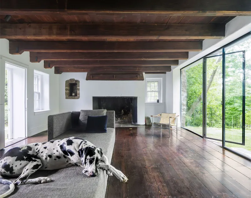 Living room with exposed timber beams and fireplace, a dalmatian resting on the floor
