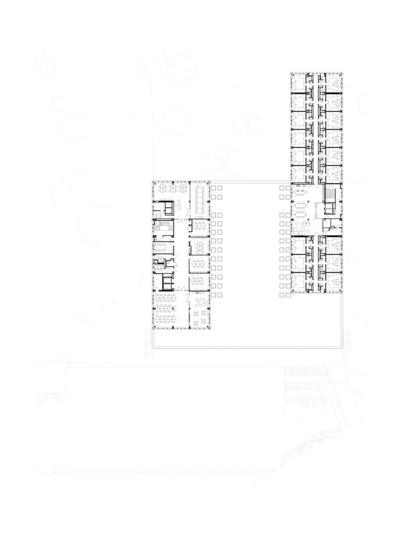 Floor plan drawing showing L-shaped wings with central courtyard and tower containing repeated residential units