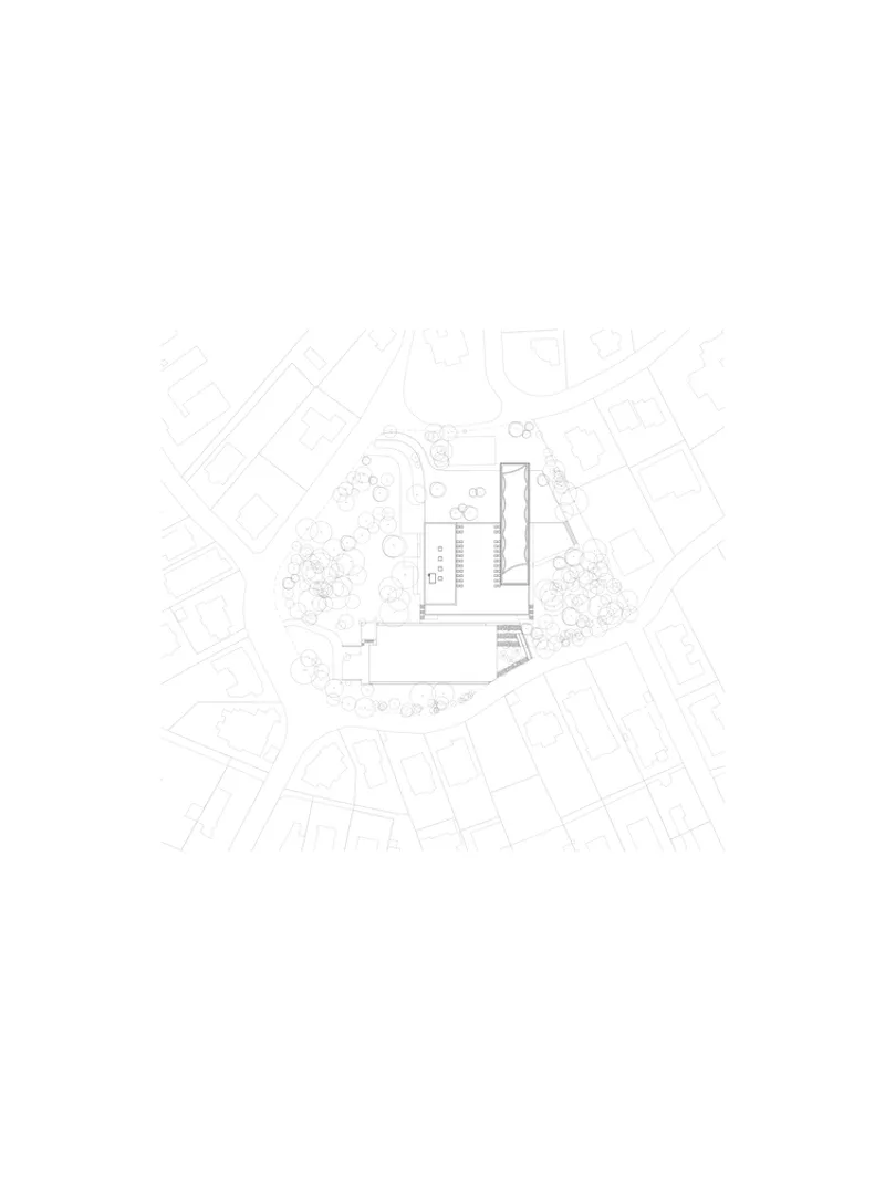 Site plan drawing showing building footprint surrounded by landscaping and adjacent urban context