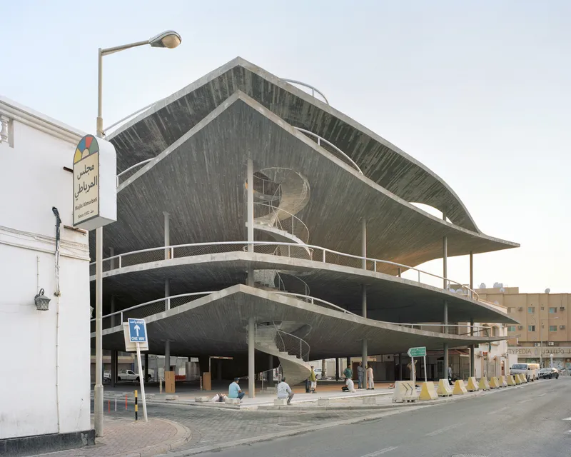 Street view of the board-formed concrete shell roof with steel railings wrapping the open levels below