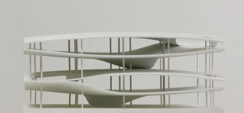 Physical model of circular multi-level structure with white columns and continuous curved floor plates