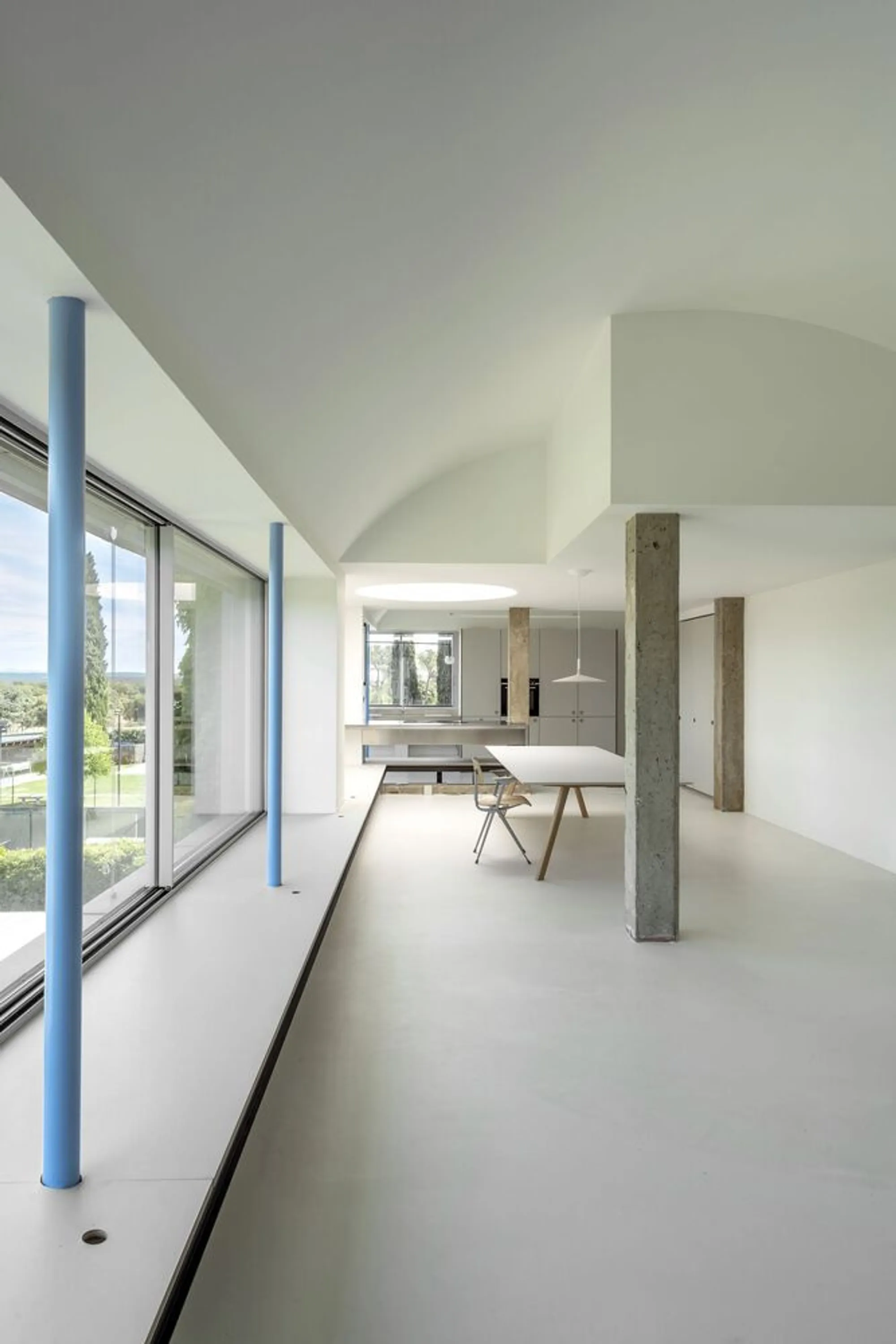 EME157 Expands a Madrid Home with Vaulted Volumes, Blue Columns, and an Ivy-Clad Facade