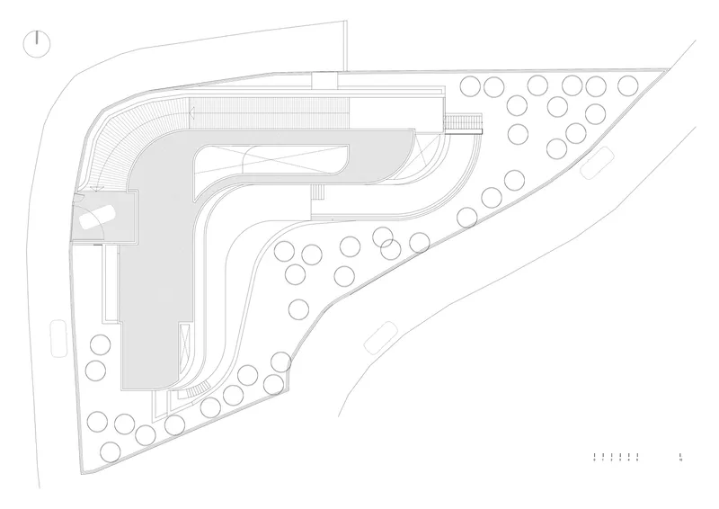 Site plan drawing showing curved building footprint with pool and trees on a sloped property