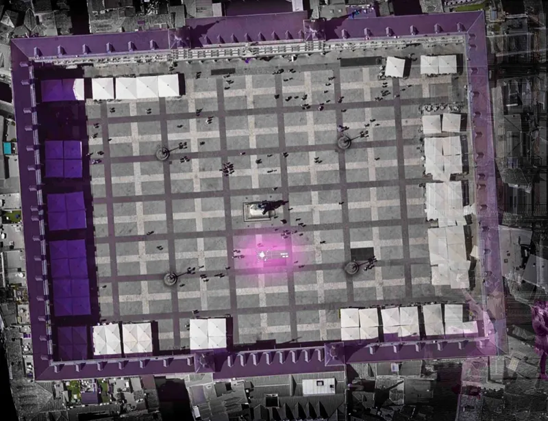 Aerial plan of the Tensegrity Blackbox deployed across Plaza Mayor: a purple-lit structural grid covers the entire square, with white event tents, gathering crowds, and a glowing magenta focal point at the centre