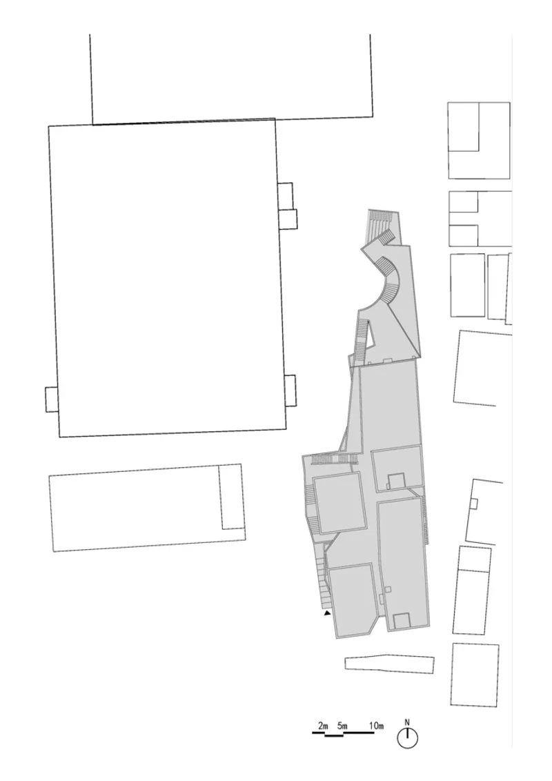 Site plan drawing showing an elongated building footprint between surrounding structures with north arrow