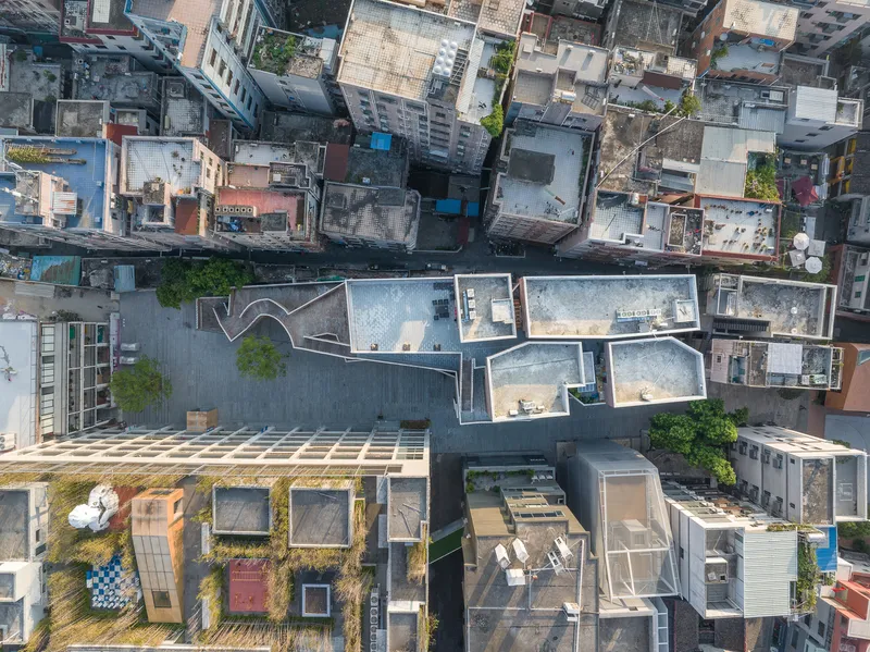 Aerial view of rooftop courtyards and patchwork of surrounding buildings in dense urban fabric
