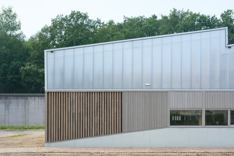 Street elevation with vertical timber slats and horizontal windows beneath translucent polycarbonate cladding
