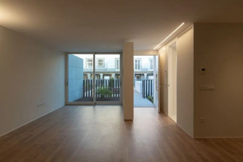 Open living space with continuous cove lighting and glazed doors opening to an exterior terrace