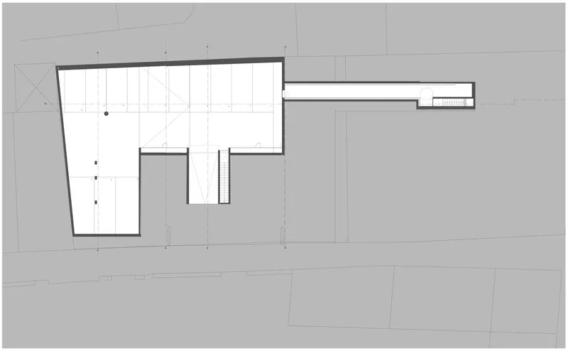 Roof plan drawing showing an L-shaped volume with a central courtyard and linear extension