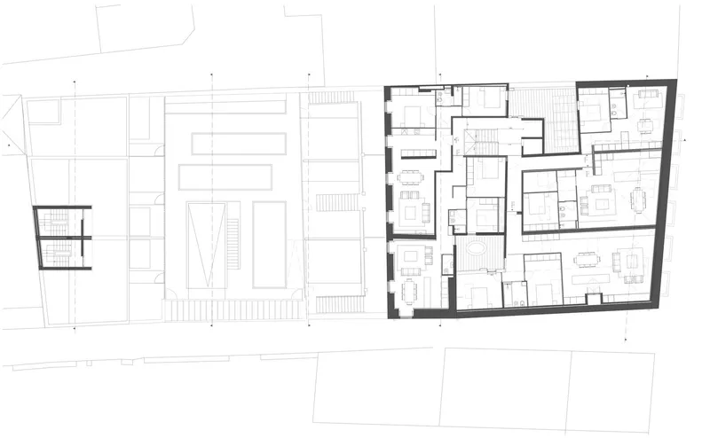 Upper floor plan drawing showing residential units with bedrooms and living areas in angled volume