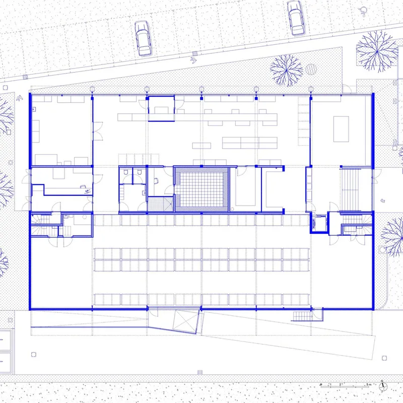 Floor plan drawing showing office spaces surrounding a central courtyard with parking and trees along the street