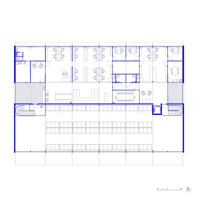 Upper level floor plan drawing with workstations, meeting rooms, and curved staircases at both ends