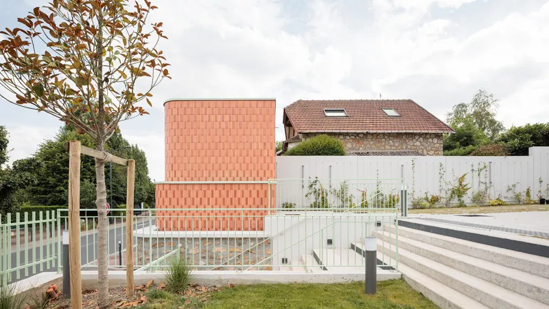 Landscaped terrace: coral terracotta tower, green metal railing, new planting, young tree, paved ground
