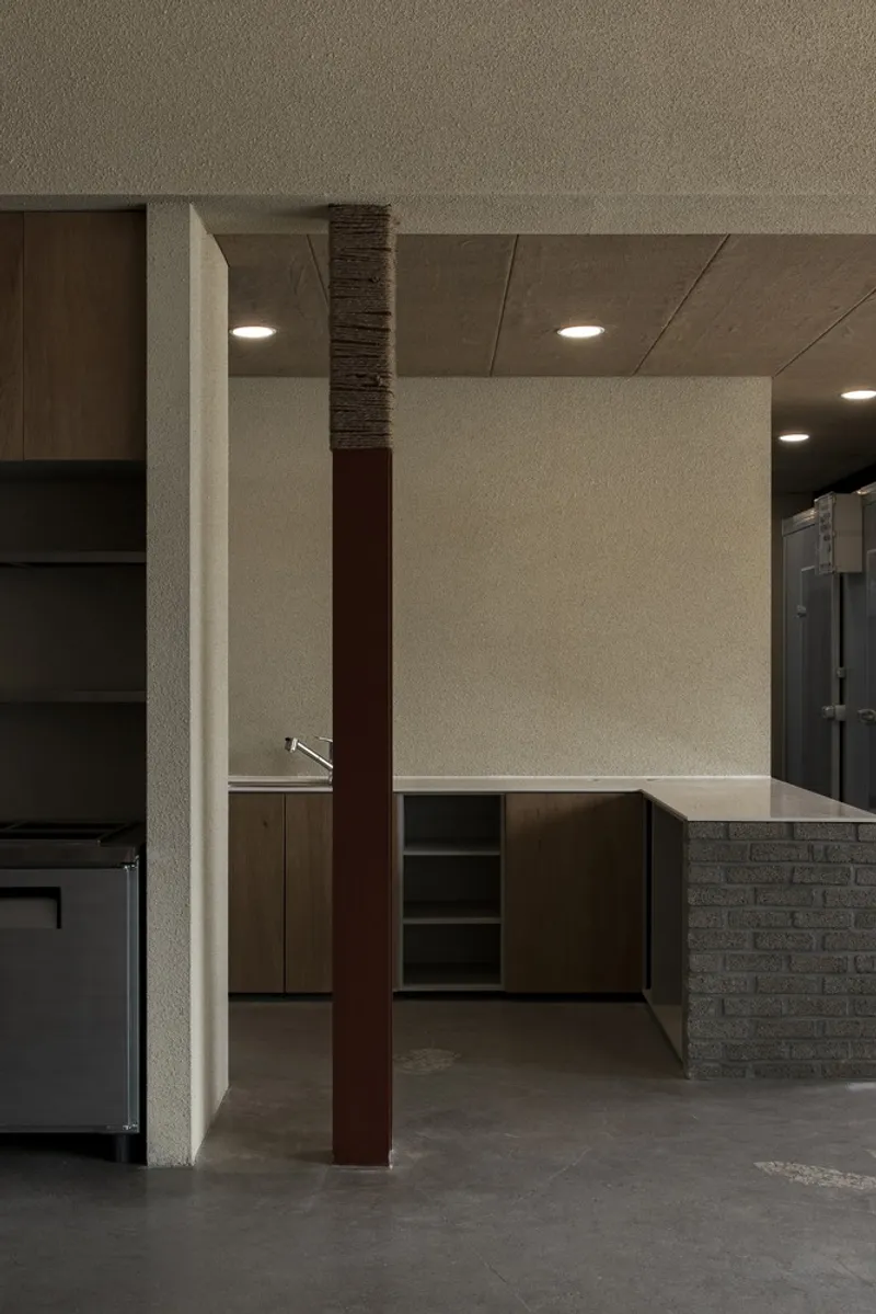 Service counter: dark timber and brick column, kitchen pass-through, stainless steel, overhead storage