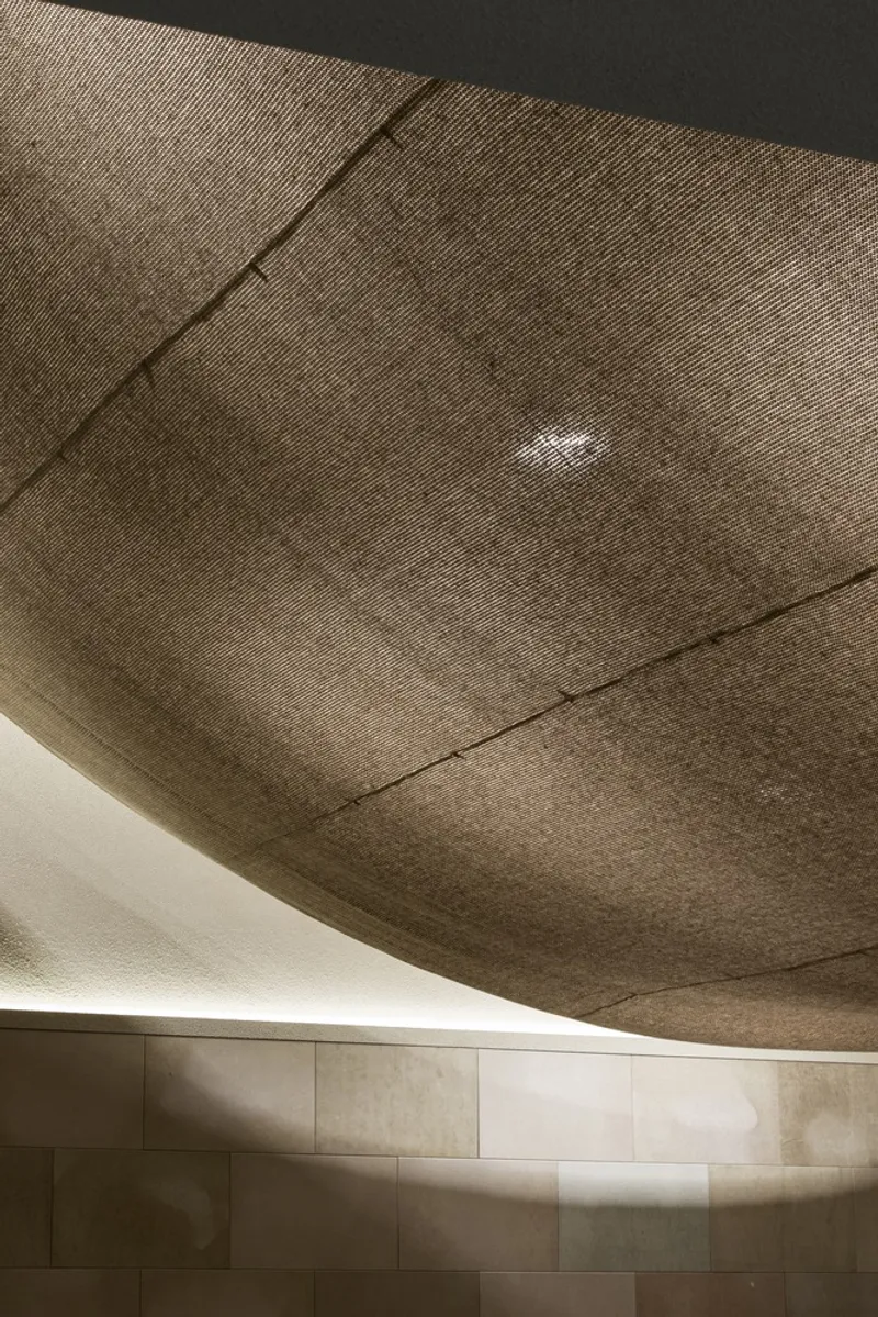 Ceiling close-up: the lacquer paper surface curving down from the gable ridge, textured and warm