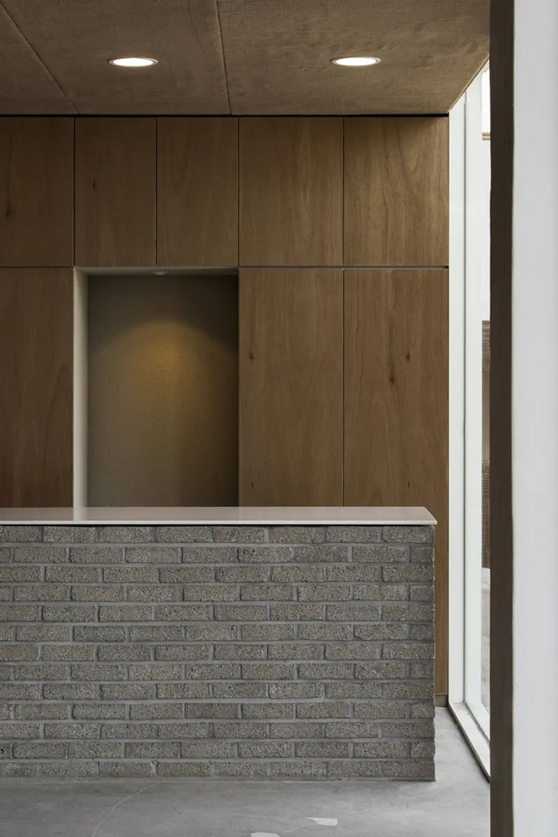 Counter detail: grey brick base, oak panel, recessed spotlight, clean junction with window frame