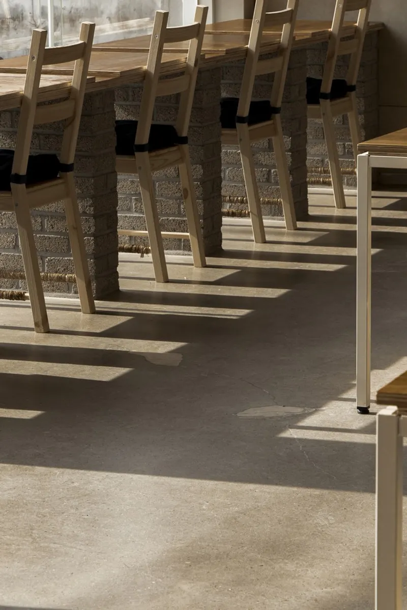 Chair shadows: afternoon light casting long shadows of timber chair legs across the polished floor