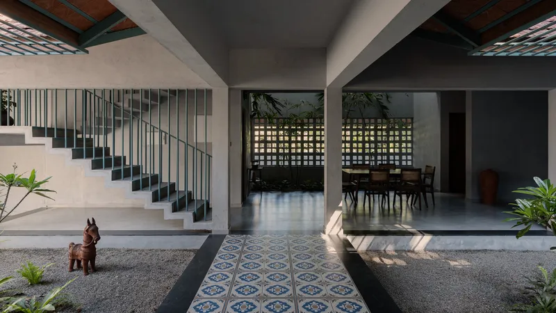 Interior courtyard with patterned tile pathway and suspended staircase with vertical metal balustrades