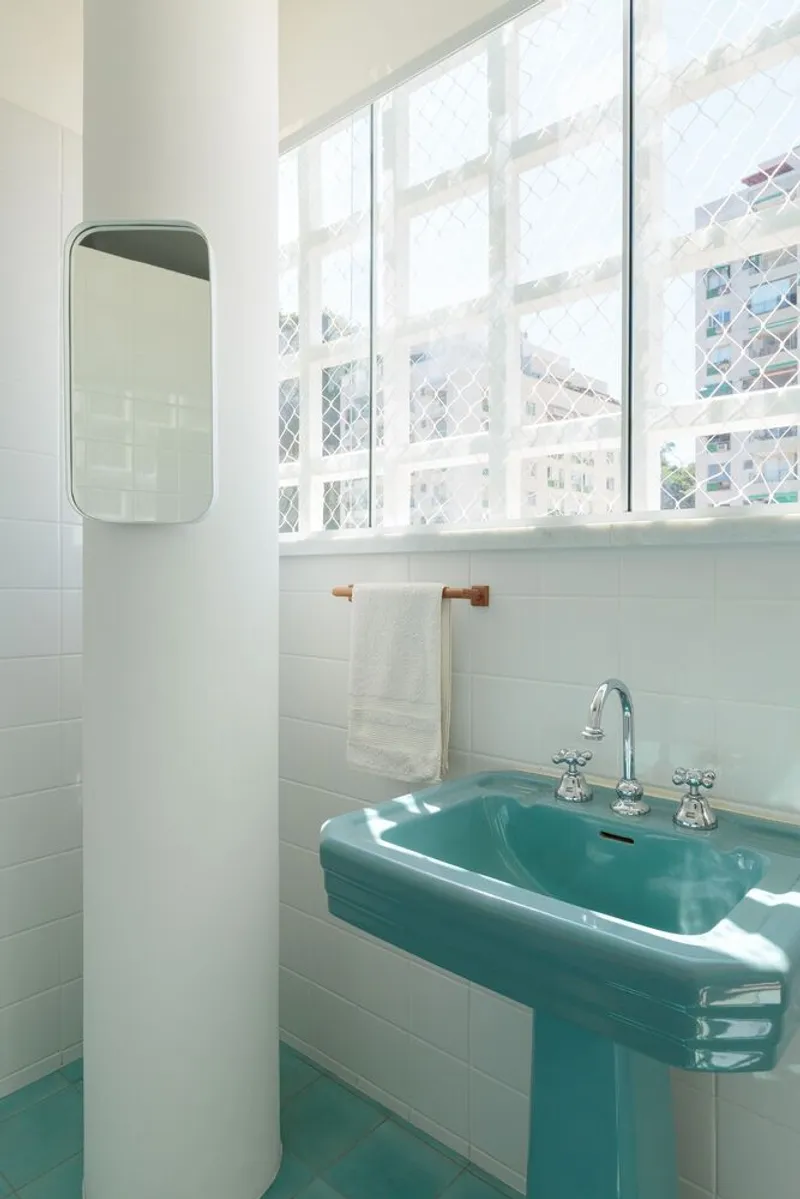 Original bathroom: turquoise pedestal basin, white tile, louvre window, column, preserved intact from 1954