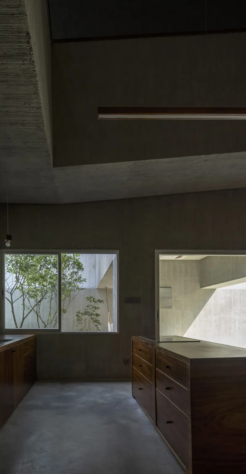 Workspace with wooden cabinetry framing a window view to an internal courtyard with trees