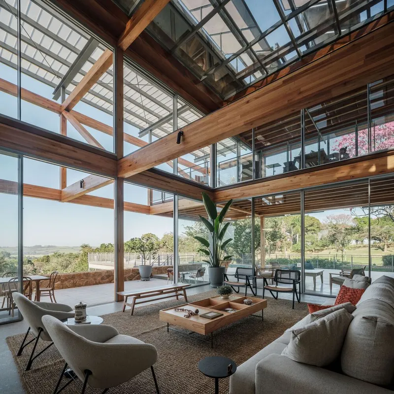 Interior view of the double-height living area with timber structure and full-height glazing