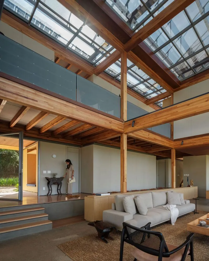 Interior view showing the mezzanine with glass balustrade and skylights above the split-level living area