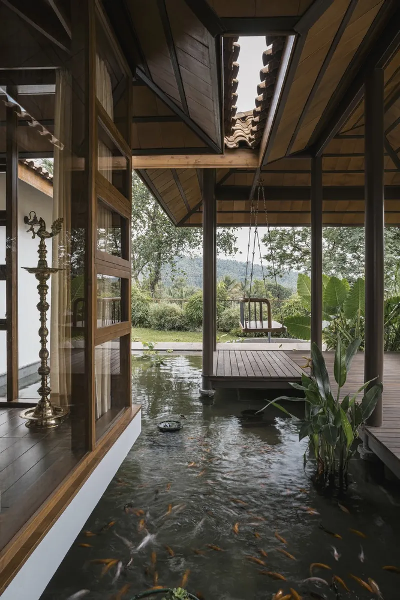 Interior courtyard pond with koi fish beneath timber-framed roof and swing suspended over water