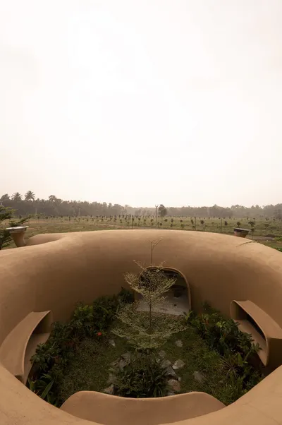 This architectural image showcases an earth-sheltered structure with a curvilinear design, seamlessl