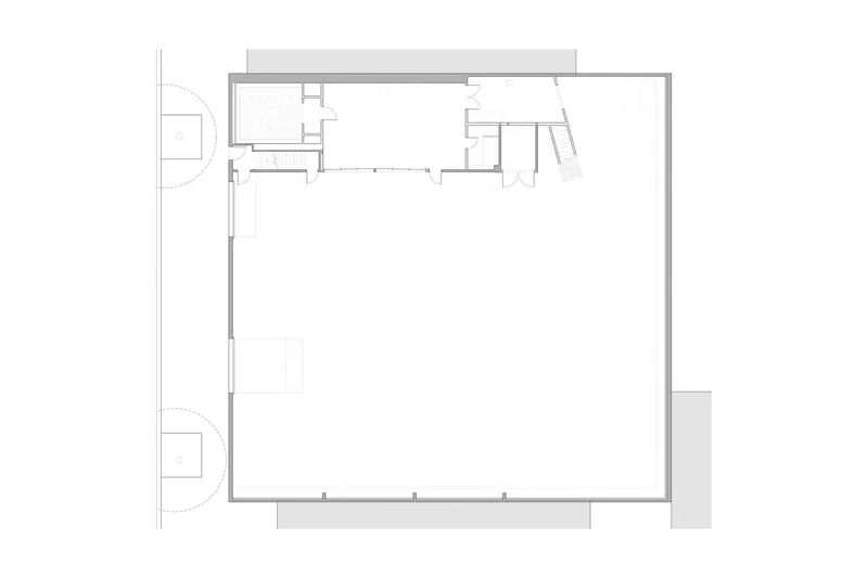 Floor plan drawing showing a rectangular open space with service areas at one corner