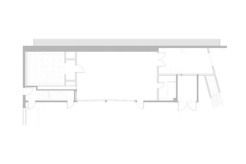Floor plan drawing showing two connected volumes with an angled outdoor deck to the right