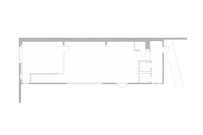 Floor plan drawing showing a narrow linear volume with bathroom and service spaces at one end