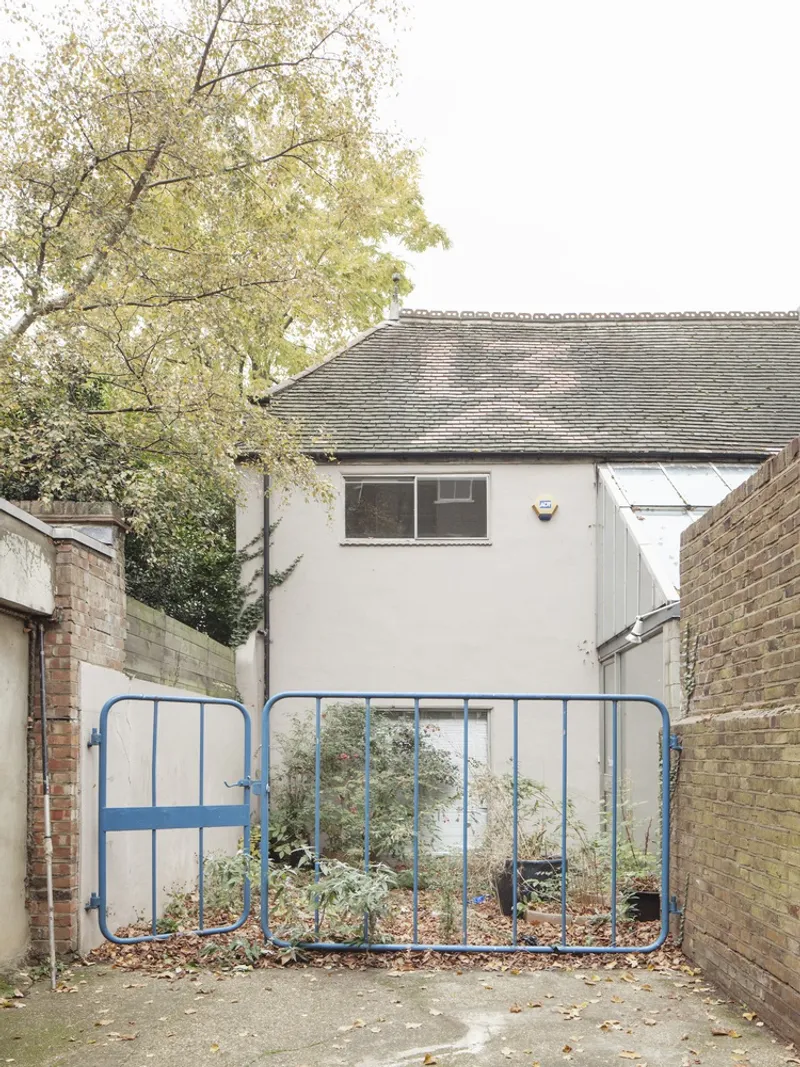 The original site: a derelict building with blue gate before transformation.
