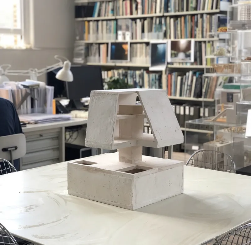 Concrete and plaster study model on the studio desk.