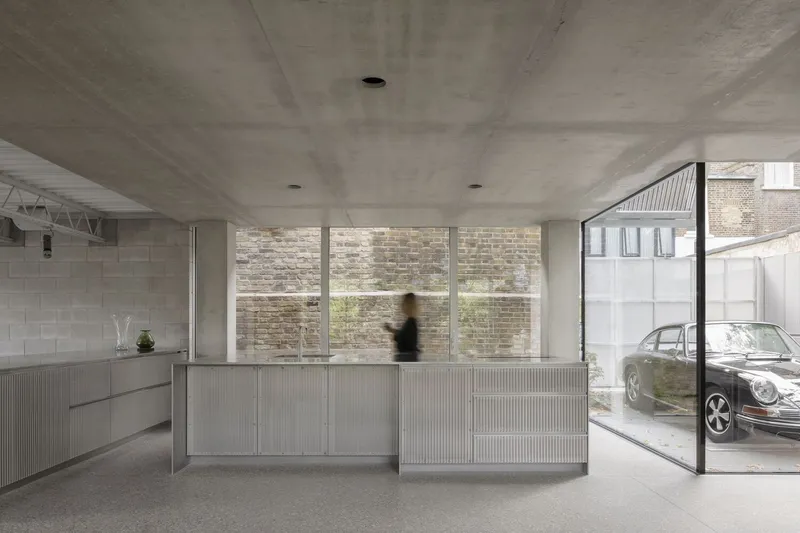 The kitchen island in stainless steel with views through glass to the narrow lane below.
