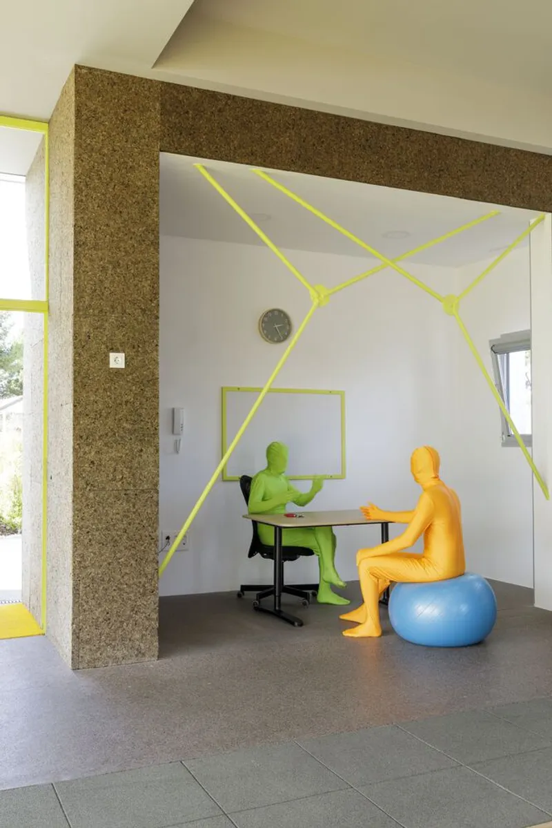 Interior workspace with cork wall and yellow geometric lines painted on white walls