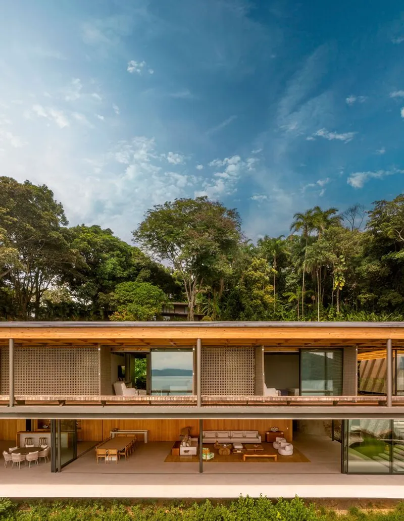 Two-story facade showing perforated screens on upper level and open living spaces below