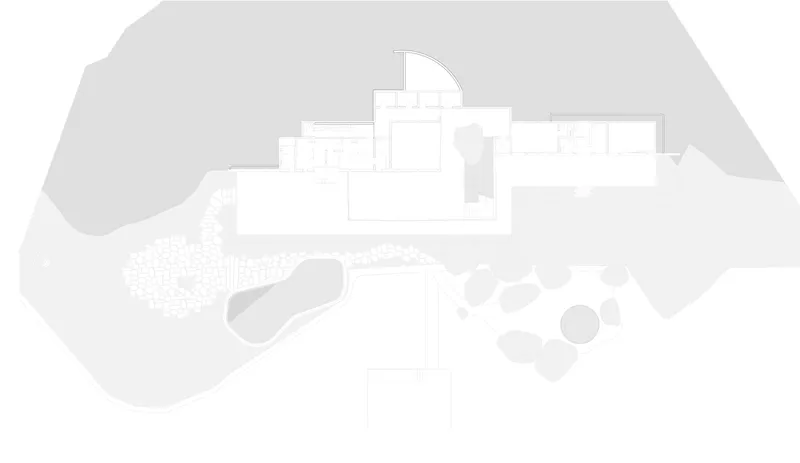 Site plan drawing showing a residence with curved pool and organic landscape on a sloping terrain