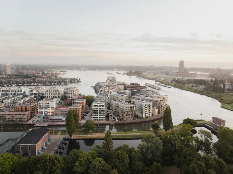 Aerial view of the residential waterfront peninsula with mid-rise buildings and canal at dusk