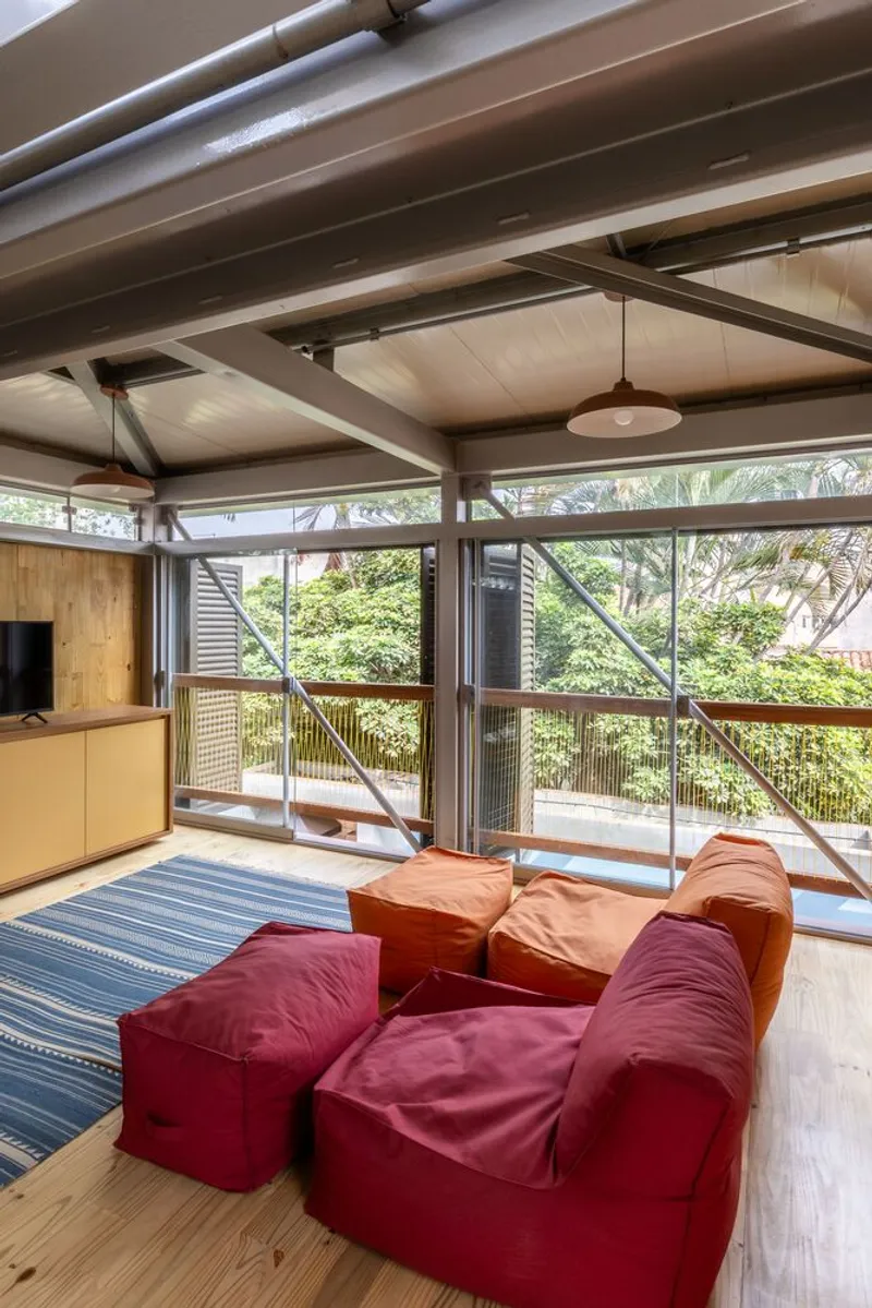 Upper-level seating area with exposed timber ceiling beams and steel columns framing views of tree canopy