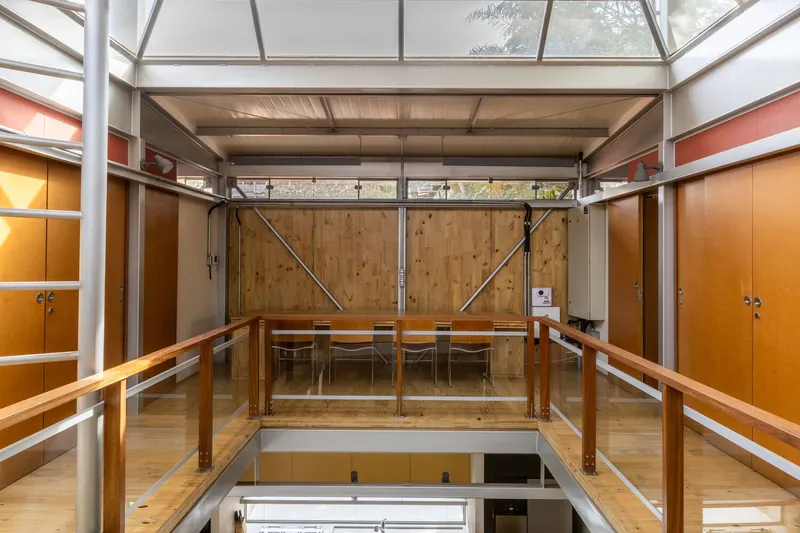 View from mezzanine overlooking the lower level with timber wall panels and steel diagonal bracing