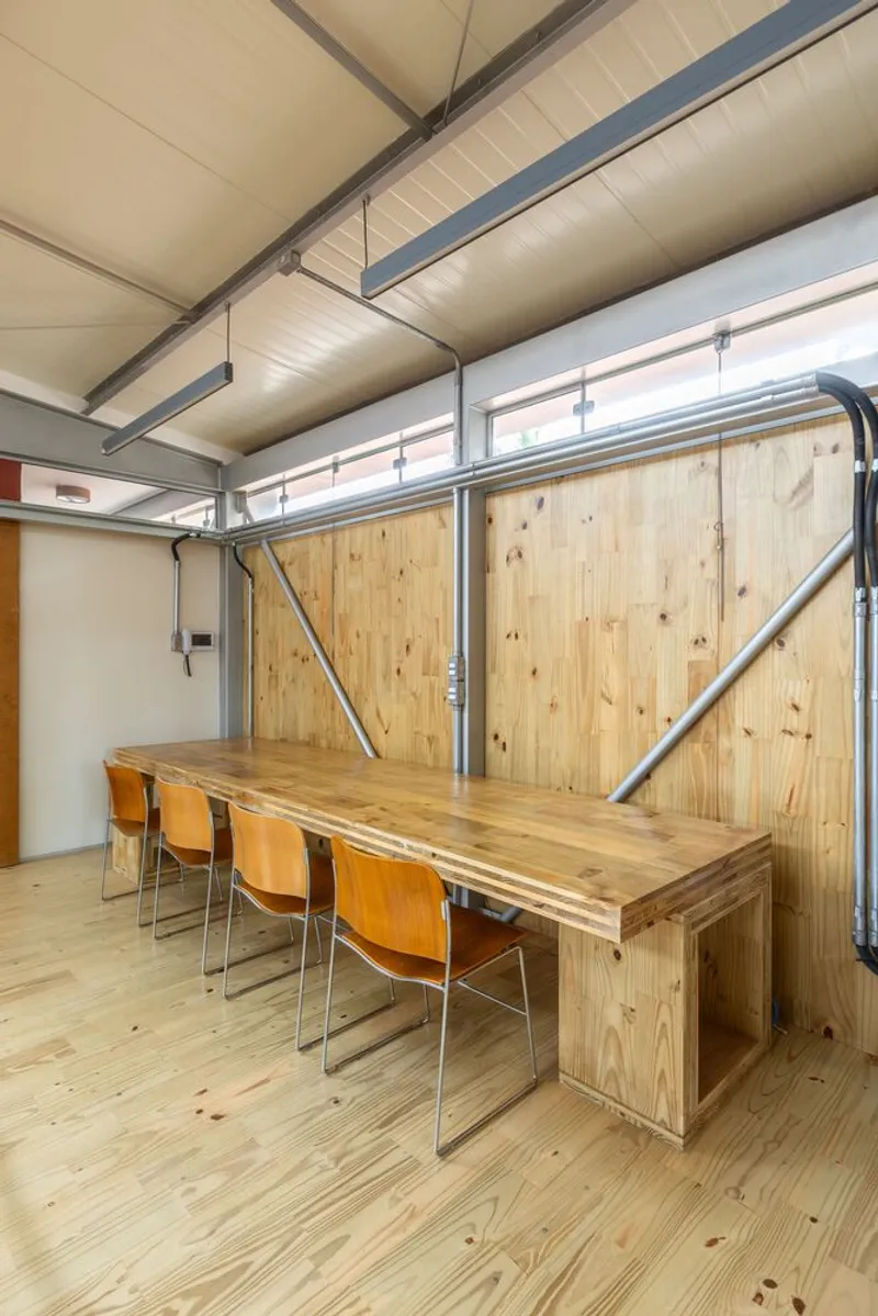 Dining area with timber table and chairs beneath a paneled ceiling and sliding timber wall