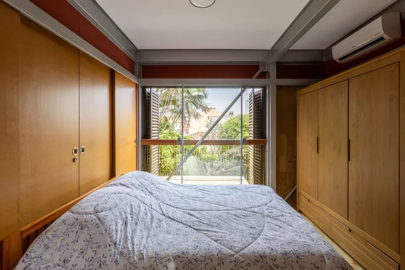 Bedroom with wood cabinetry and sliding glass door opening to balcony with palm trees beyond