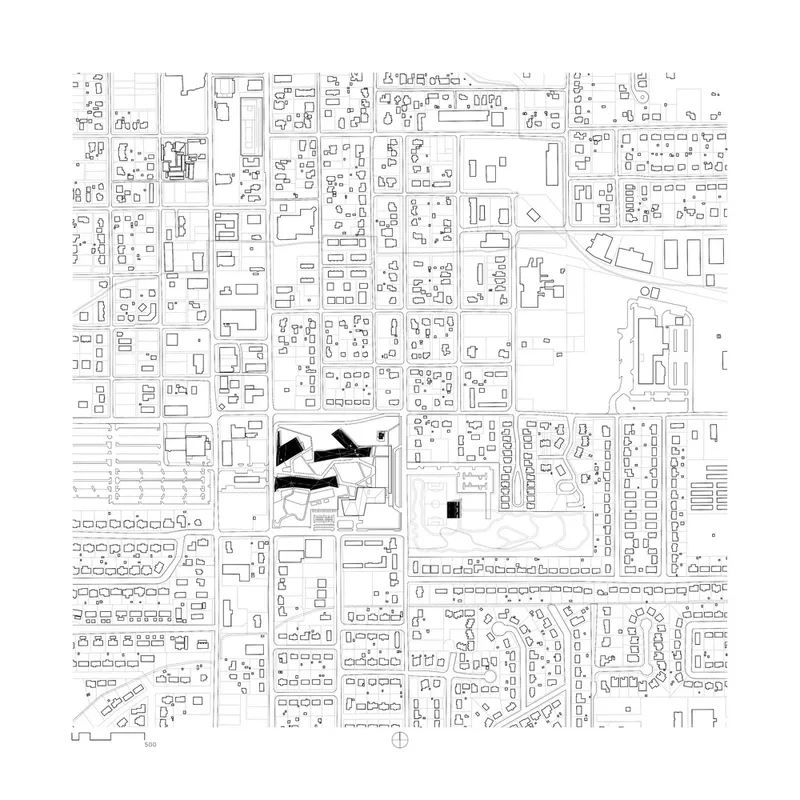 Site plan drawing showing angular buildings positioned within a rectilinear street grid and surrounding neighborhood
