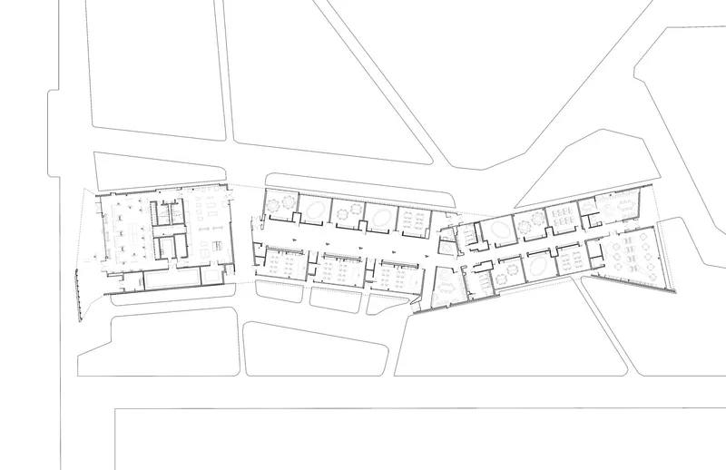 Floor plan drawing showing a linear arrangement of rooms along an angled corridor with adjacent buildings