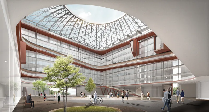 Interior courtyard with layered terracotta balconies beneath a curved triangulated glass roof and people below