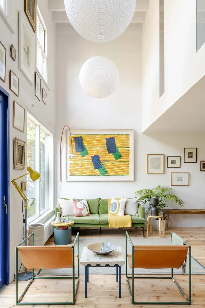 Living room with paper lanterns and framed artworks under natural light from tall windows