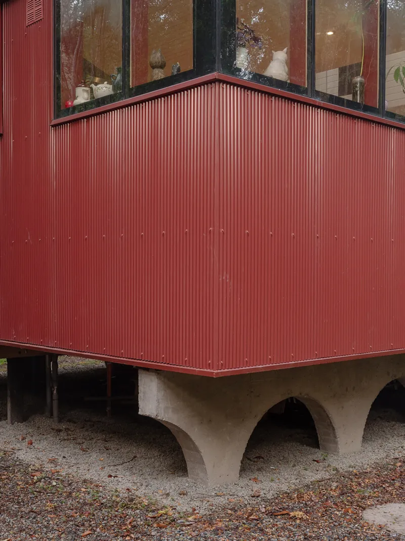 Corner view of corrugated metal cladding meeting the arched concrete base below